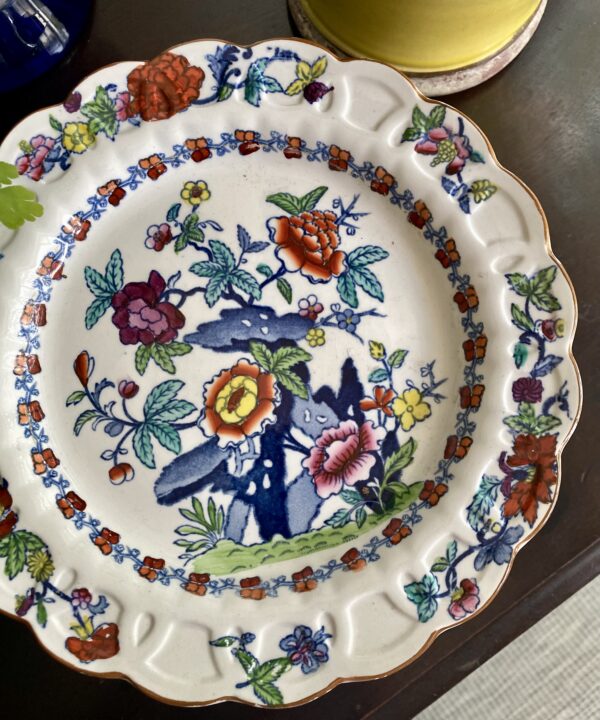 Detail of a colourful, floral antique cake stand.