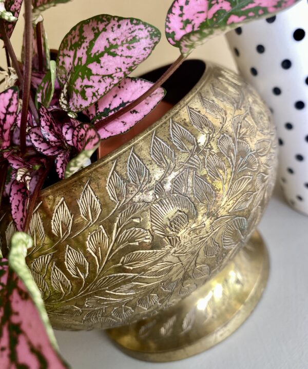 A vintage brass rose bowl or vase with engraved detailing.