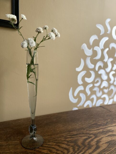 A tall, single stem bud vase with grey glass knot detail.