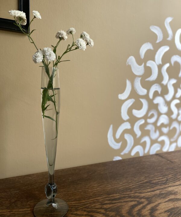 A tall, single stem bud vase with grey glass knot detail.