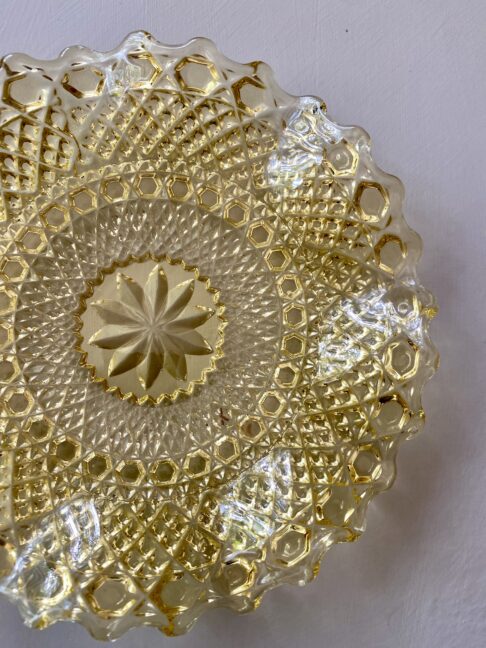 Overhead shot of a pressed glass plate in a golden colour.