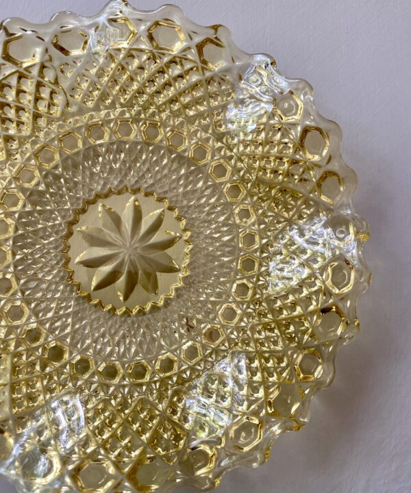 Overhead shot of a pressed glass plate in a golden colour.