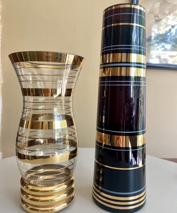 Two retro glass vases; one black, on clear; each with gold banding.