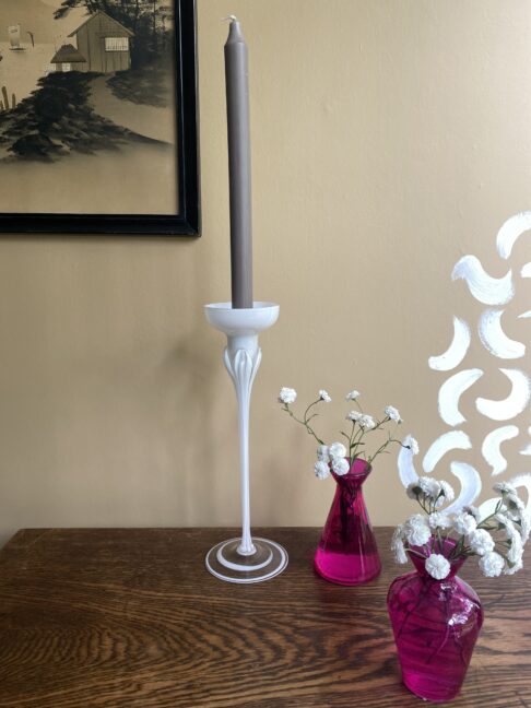 A tall, white glass candlestick.