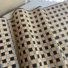 A woven rattan table runner in black and grey.