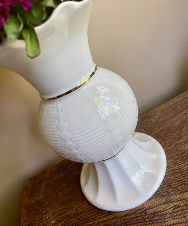 Detail of a footed Donegal Parian ware vase in cream and gold.