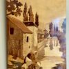 A vintage, wooden inlay wall art panel depicting a canalside scene with a woman washing laundry.