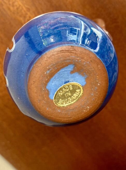 Underside of a Bulgarian art pottery piece with a gold 'made in Bulgaria' sticker.