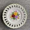 A wall plate with decorative florals hand-painted in bright colours.