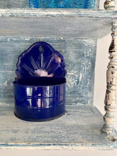 A vintage blue enamel wall storage caddy.