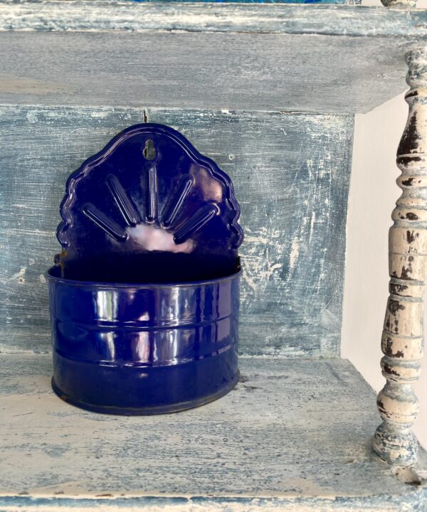 A vintage blue enamel wall storage caddy.