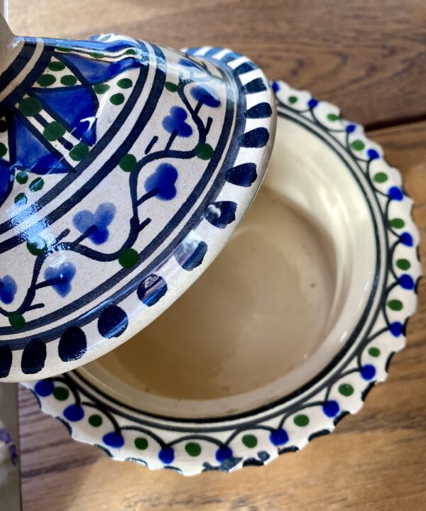 A cream ceramic lidded pot with hand-painted patterning.