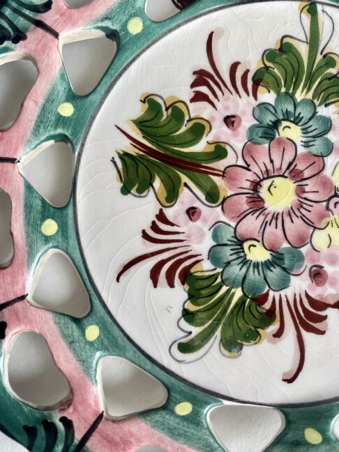 Close up of a vintage Portuguese pottery plate hand-painted and with slight crazing due to age.