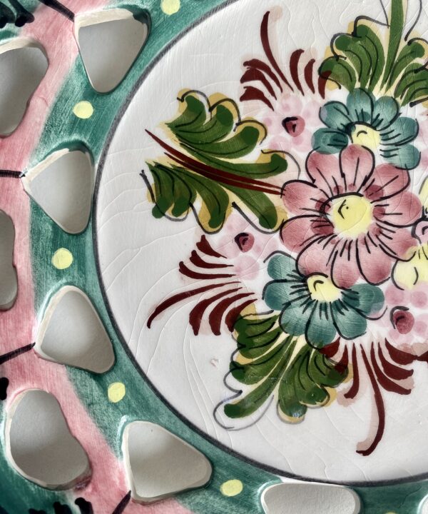 Close up of a vintage Portuguese pottery plate hand-painted and with slight crazing due to age.