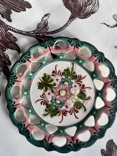 A pretty Portuguese pottery wall plate with floral décor and reticulated edges.