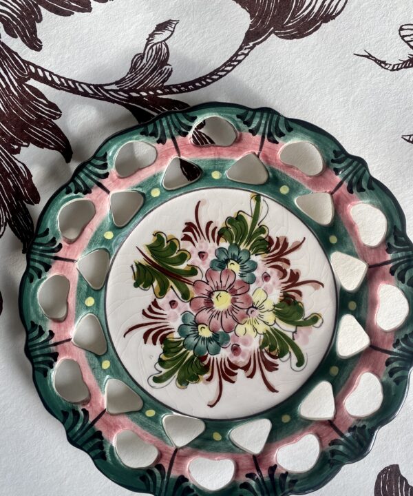 A pretty Portuguese pottery wall plate with floral décor and reticulated edges.