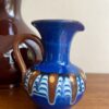 A miniature andmade pottery jug hailing from the Bulgarian Troyan tradition.