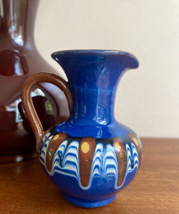 A miniature andmade pottery jug hailing from the Bulgarian Troyan tradition.