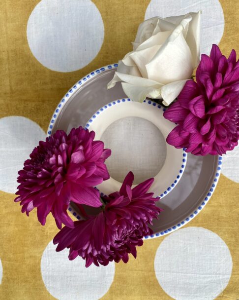 A posy ring seen from above on a yellow, polka dot tablecloth.