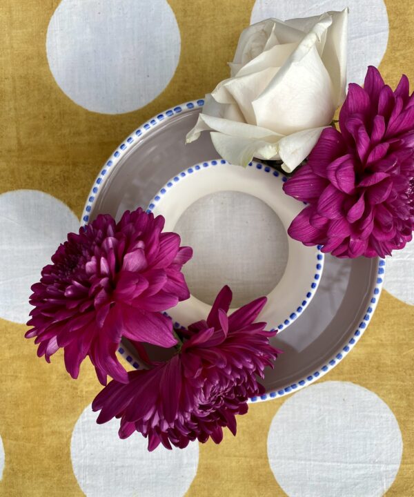 A posy ring seen from above on a yellow, polka dot tablecloth.