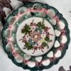 A vintage Portuguese wall plate with pretty floral hand-painted decoration in green and pink.