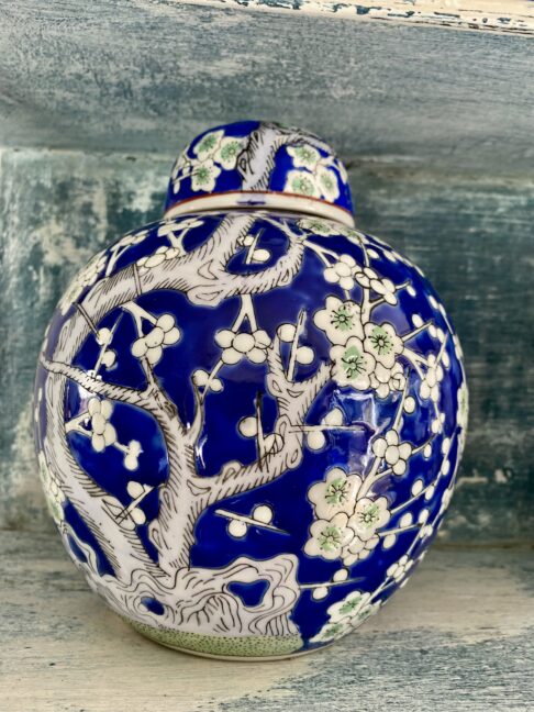 Blue glazed decorative pot with lid depicting a flowering blossom tree in green and white.