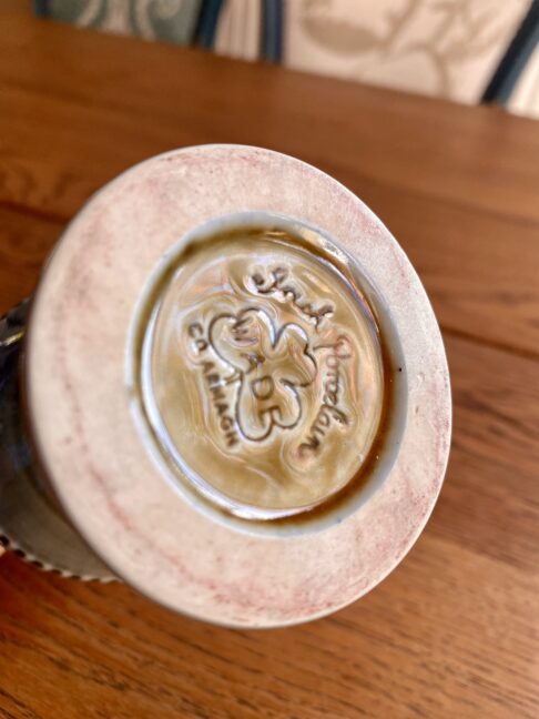 The back stamp on an Irish craft pottery showing a shamrock on a goblet by Wade.