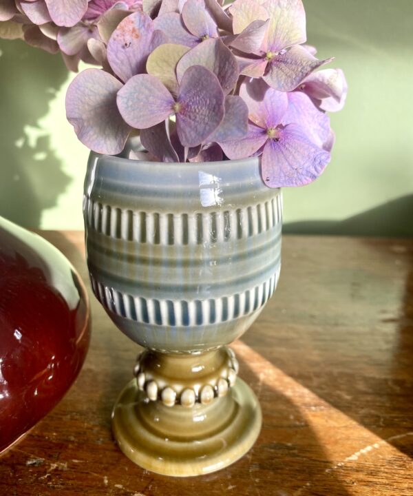 A vintage Irish pottery bud vase or goblet by Wade, filled with dusky pink hydrangea blooms.