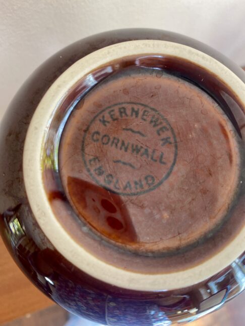 The back stamp on a vintage brown ceramic vase by the Cornish Kernewek pottery.