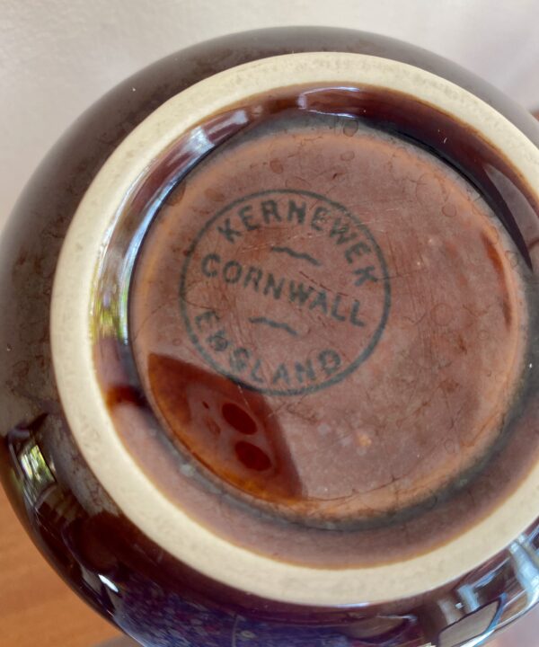 The back stamp on a vintage brown ceramic vase by the Cornish Kernewek pottery.