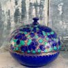 Indian papier mâché box with domed lid in vibrant Royal blue with gilt and green accents. Styled on antiqued blue shelving.