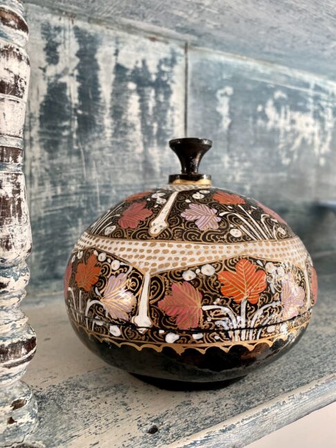 A vintage trinket pot with a domed lid, hand-painted in India.