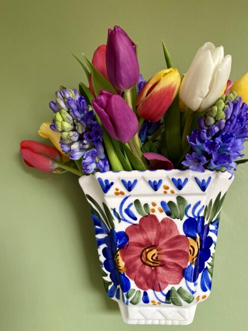 A wall vase filled with colourful Spring flowers.