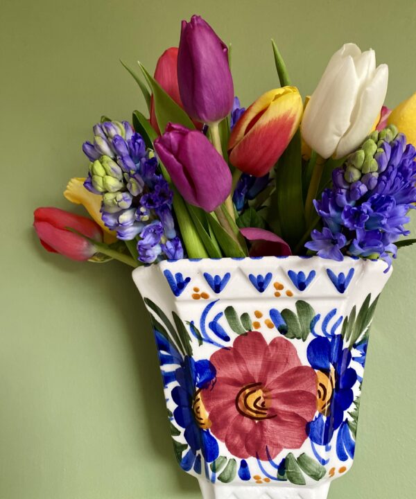 A wall vase filled with colourful Spring flowers.