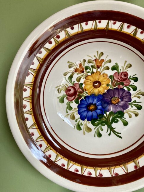 A pretty, vintage wall plate with floral design.