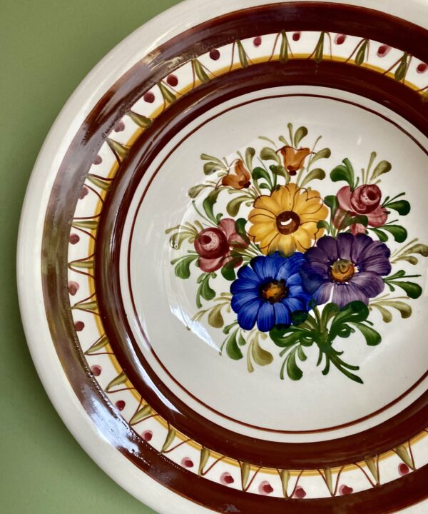 A pretty, vintage wall plate with floral design.