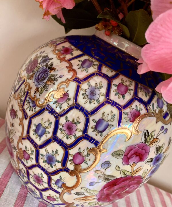 Decorative detail on a vintage, ginger-jar style vase or pot with floral and gilt detailing from China.