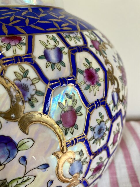 Lattice-work detailing in blue, pink and white with gold accents on a vintage Chinese vase.