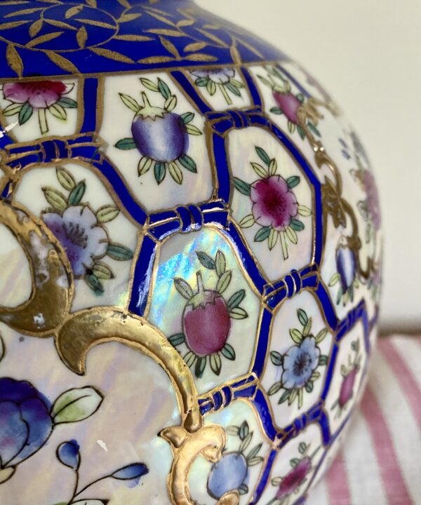 Lattice-work detailing in blue, pink and white with gold accents on a vintage Chinese vase.