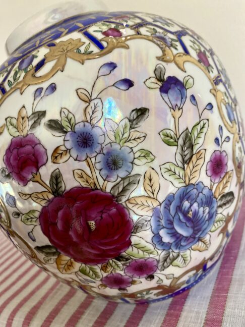 P{ink rose design with blue, white and gold detailing on a vintage Chinese pot or vase.