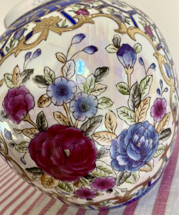 P{ink rose design with blue, white and gold detailing on a vintage Chinese pot or vase.