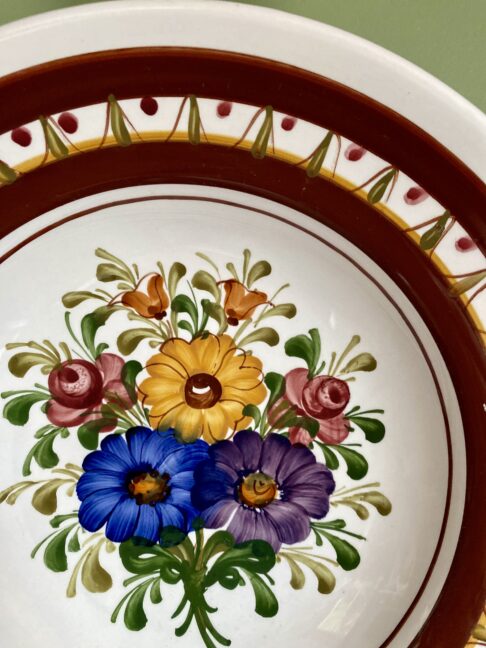 Floral detail on a hand-painted wall plate from Austria.