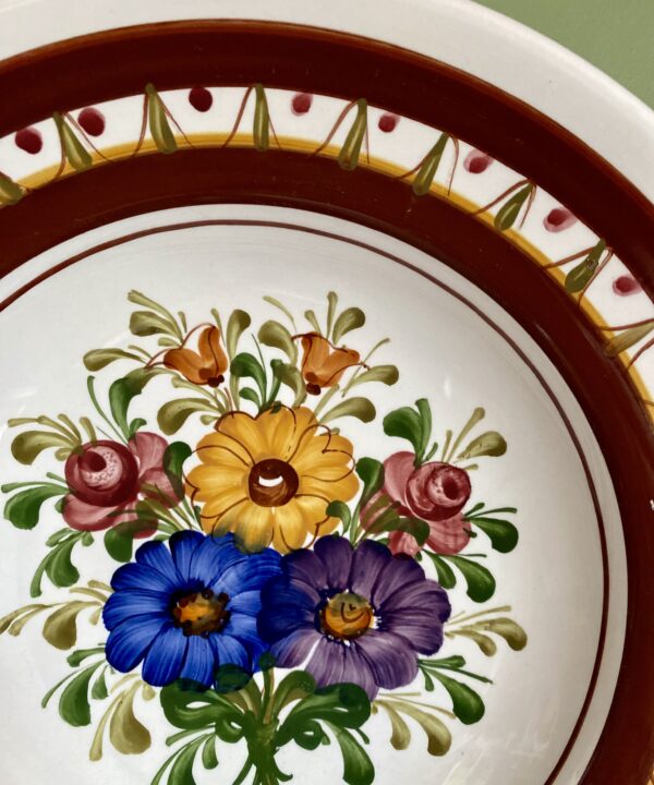 Floral detail on a hand-painted wall plate from Austria.