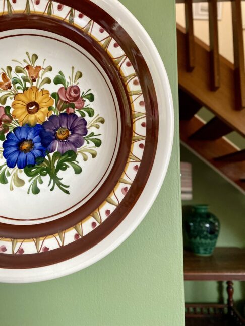 A hand-painted floral design on a decorative, Austrian wall plate.