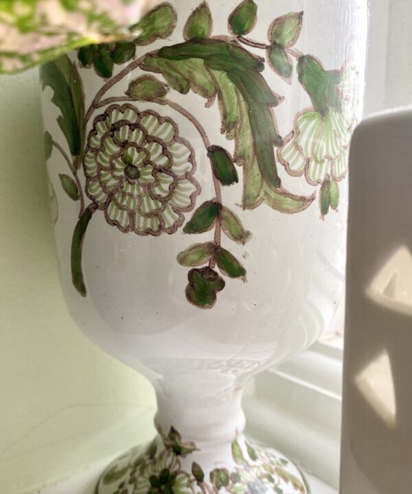 Green, hand-painted floral detailing on a vintage Portuguese vase.