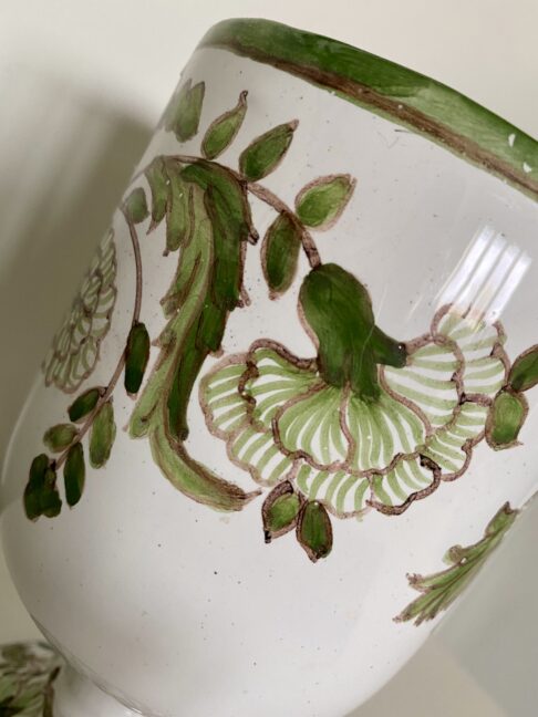 Floral detail on a hand-painted Portuguese vase in green.