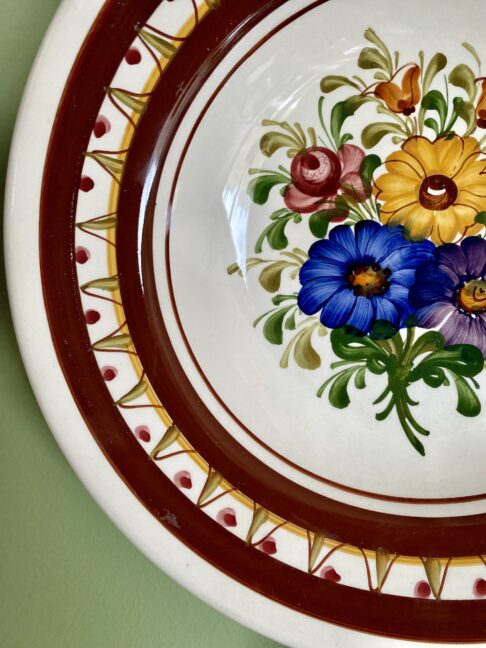 Hand-painted decoration on a vintage, Austrian wall plate.