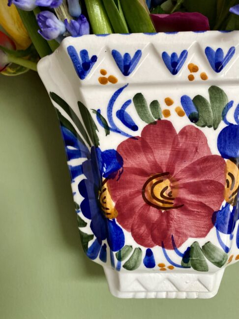 Close up detail of hand-painted florals on a Portuguese traditional wall vase.