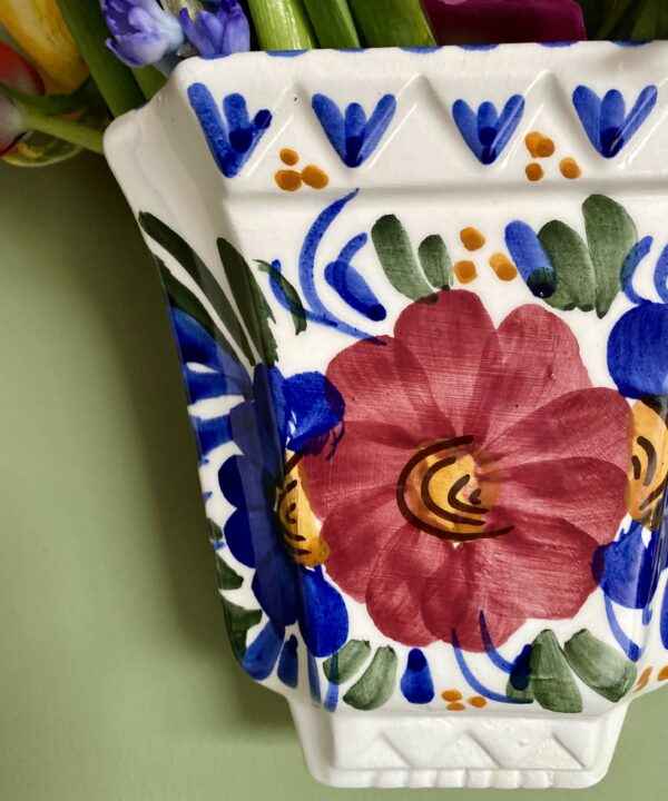 Close up detail of hand-painted florals on a Portuguese traditional wall vase.