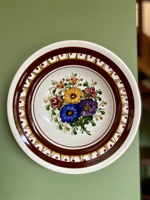 A colourful wall plate with flower decoration.